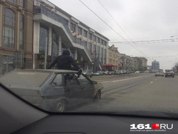В центре Ростова молодой человек "оседлал" автомобиль