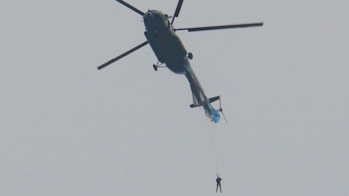 Парашютист повис на вертолете после неудачного прыжка. Видео