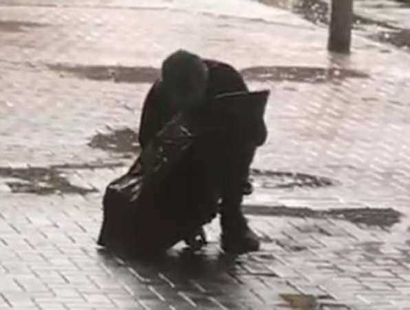 Странный мужчина с зонтом «приснул» посреди улицы в Ростове и попал на видео